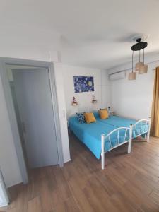 a bedroom with a blue bed in a room at Kosinmyheart Apartment 11 & Studio10 in Kos