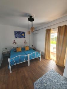 a bedroom with a blue bed and a window at Kosinmyheart Apartment 11 & Studio10 in Kos