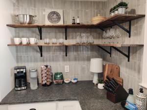 a kitchen with a counter with glasses on shelves at Living Easley Manor - With Amazing Hot Tub! in Easley