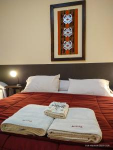 Una cama con toallas encima. en Hotel de la Linda en Salta