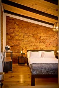 sypialnia z łóżkiem i ceglaną ścianą w obiekcie Hotel Casa Luna w mieście Zafra