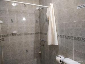 a bathroom with a shower with a white towel at Hotel de la Linda in Salta
