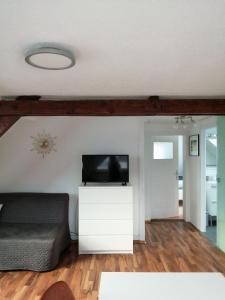 uma sala de estar com televisão numa cómoda branca em Ferienwohnung Jule II em Grenzach-Wyhlen
