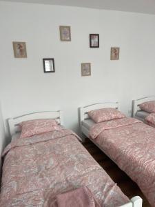 2 camas en un dormitorio con fotos en la pared en Dedina kuća en Gornji Milanovac