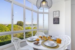 奧傑斯的住宿－WHome Peaceful River Views in Algés perfect for Families，白色的用餐室配有桌椅和窗户。
