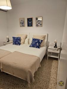 塞維利亞的住宿－Plaza de Armas，一间卧室配有两张带蓝白色枕头的床