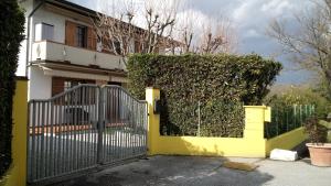 a yellow gate with a hedge in front of a house at Verdazzurro in Camaiore