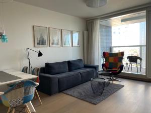ein Wohnzimmer mit einem Sofa, einem Tisch und Stühlen in der Unterkunft Panorama City apartment 2 rooms 19th floor, free parking in Bratislava
