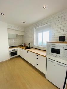 a kitchen with white cabinets and a sink and a window at Arunda Home in Ronda +8 photos