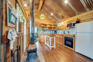 a kitchen with a white refrigerator and wooden walls at Pet-Friendly Kerrville Vacation Rental Farmhouse in Kerrville