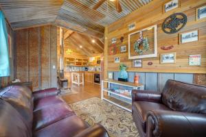 a living room with a leather couch and wooden walls at Pet-Friendly Kerrville Vacation Rental Farmhouse in Kerrville