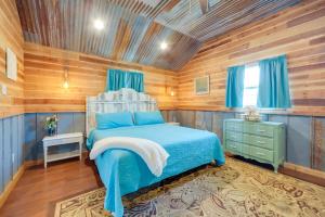 a bedroom with a blue bed and wooden walls at Pet-Friendly Kerrville Vacation Rental Farmhouse in Kerrville