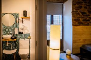 een badkamer met een toilet en een spiegel bij Hotel Casa Luna in Zafra