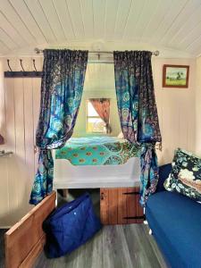 a small bedroom with a bed in a trailer at Alice’s Garden @ Bleak House Farm in York