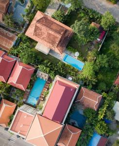 uma vista superior de uma casa com piscinas em The Elephant em Siem Reap