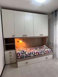 a bedroom with a bed with white cabinets at Civico 13 in Scardovari