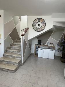 a clock on the wall above a staircase with a clock at Civico 13 in Scardovari