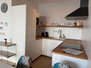 eine kleine Küche mit weißen Schränken und einem Waschbecken in der Unterkunft Panorama City apartment 2 rooms 19th floor, free parking in Bratislava