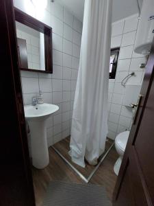 a white bathroom with a sink and a toilet at HostelChe Guest House in Smederevo