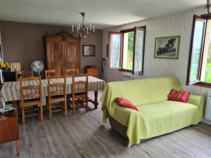 a living room with a table and a yellow couch at commealaferme71.vacances in Montret