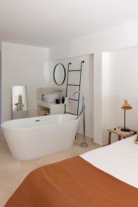 eine weiße Badewanne in einem Zimmer mit einem Bett in der Unterkunft Domaine de la Xavolière in Saint-Cézaire-sur-Siagne