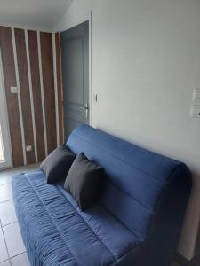 a blue couch in a room with two pillows on it at Studio 4 personnes in Montagne