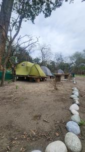 grupa namiotów i skał na polu w obiekcie Beyond Brahmaputra Campsite 
