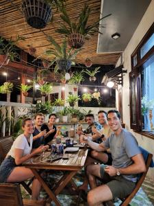 een groep mensen aan een tafel in een restaurant bij Monkey Homestay & Bar in Tân Hiệp