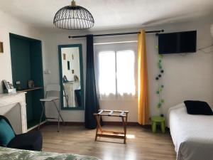 a room with a bed and a window with a table at Hotel Le Flore in Fréjus +59 photos