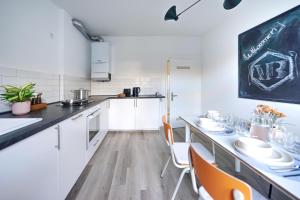 a kitchen with white cabinets and a chalkboard on the wall at Therme - zentral - Gruppen - 3 SZ - vonBehling in Wiesbaden +29 photos