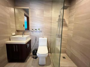 a bathroom with a toilet and a sink and a mirror at Cozy Spacious Hotel Type Condo with PS5 Smart TV and WiFi in Manila