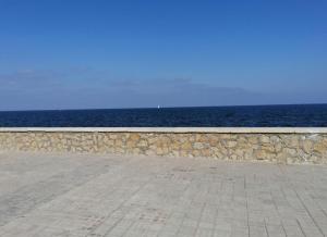 a stone wall next to the ocean with the ocean at L'amuri du mare in Trapani +30 photos
