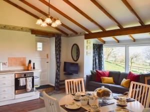 a living room with a table and a couch at Little Folly in  Liscombe