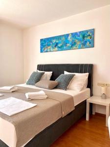 a bedroom with a large bed with a painting on the wall at Villa Mihaela - Apartment Ika in Cesarica