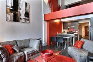 ein Wohnzimmer mit einem Sofa und einem Tisch in der Unterkunft Les Immeubles Charlevoix - Le 1180 in Québec
