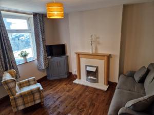 a living room with a couch and a fireplace at Lovely Cosy Two Bed Home,Peak District Gateway in Buxton