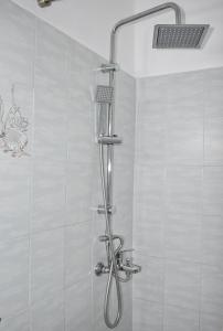 a shower with a shower head in a bathroom at Filio rooms in Kýthira