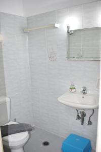 Baño blanco con lavabo y aseo en Filio rooms en Kýthira