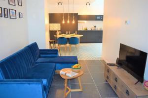 a living room with a blue couch and a tv at Home Sweet Home Brussels center in Brussels