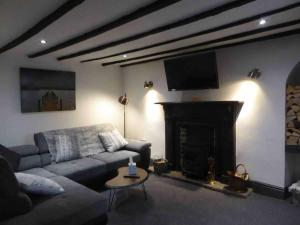 a living room with a couch and a fireplace at Quirky Cottage in the Heart of Appleby in Appleby
