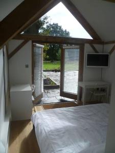 a bedroom with a bed and a large window at Oak Frame Barn Studio in Rural AONB Chiddingfold in Chiddingfold
