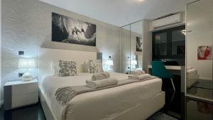 a white bedroom with a bed and a mirror at Sea and Sun 4 You - Jardins da Imperatriz in Funchal