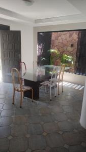 comedor con mesa de cristal y sillas en Get Up Hostel, en Natal