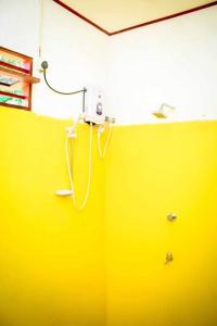 a yellow wall with a phone on the wall at Talalla Freedom Resort in Talalla