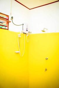 a yellow wall with a phone on the wall at Talalla Freedom Resort in Talalla South
