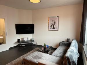 un soggiorno con divano e TV a schermo piatto di Appartement Wim a Blankenberge