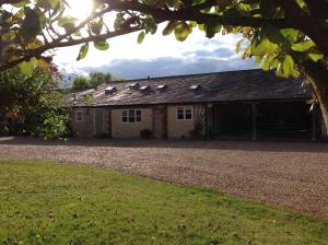 un grande fienile di mattoni con un vialetto di ghiaia di Hollyhock Cottage, Clematis cottages, Stamford a Stamford