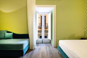 Cette chambre comprend un lit, un canapé et une fenêtre. dans l'établissement La Casa di Vittoria Sorrento, à Sorrente
