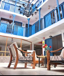 Habitación con 2 sillas y lámpara de araña. en SAN BLAS PLAZA INn, en Cusco