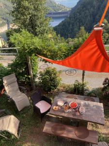 MergosciaにあるCasa Bruja Tradizionale Rustico Ticineseのピクニックテーブル、湖の景色を望むハンモック